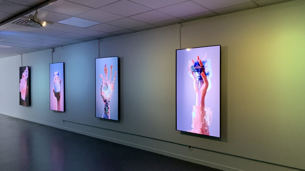 Exposition « Ménagerie d’Ecrans » 
4 écrans disposé au format vertical sont accroché au mur. Chaque écran montre une main interagissant avec un téléphone portable.